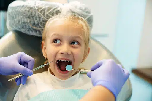 Young child receiving a dental exam during early orthodontic treatment for children consultation